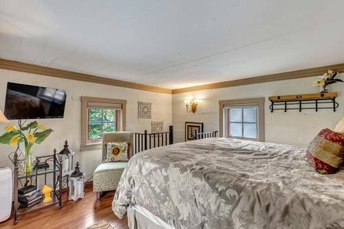 a bedroom with a bed and a flat screen tv at The Rock House Hideaway - TANK HOUSE in Fredericksburg