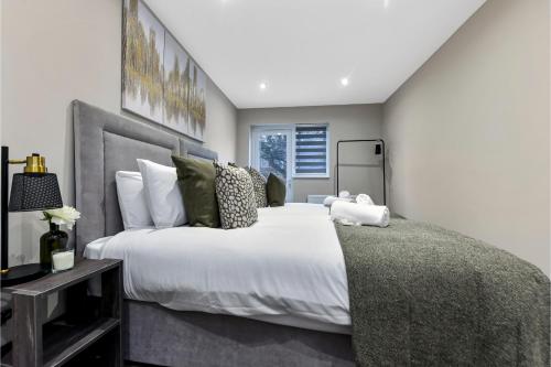 Un dormitorio con una gran cama blanca y una ventana en City Paradise- 3 BDR Flat w/ Spacious Garden en Greenford