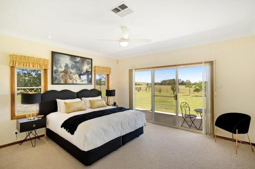 a bedroom with a large bed and a large window at Black Creek Paddock in Lovedale