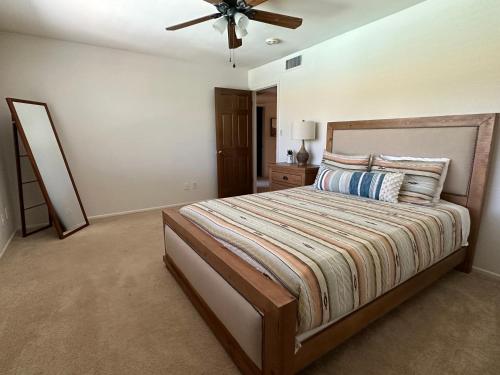 a bedroom with a large bed with a ceiling fan at Paradise in Scottsdale with Pool Oasis & Game Room in Phoenix