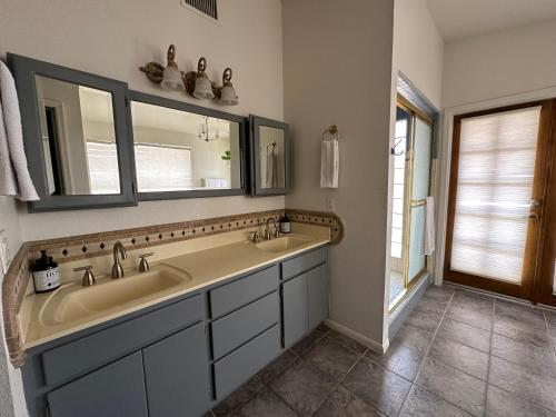 a bathroom with two sinks and two mirrors at Paradise in Scottsdale with Pool Oasis & Game Room in Phoenix