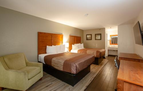 ein Hotelzimmer mit 2 Betten und einem Stuhl in der Unterkunft Hotel Serene in Glendale