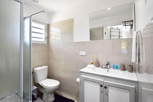 bagno con servizi igienici, lavandino e specchio di Balconies at Grand Case a Grand Case