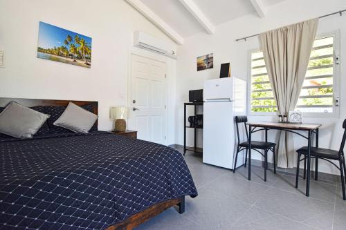 1 dormitorio con 1 cama, mesa y nevera en Balconies at Grand Case, en Grand Case