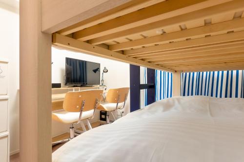 1 dormitorio con 1 cama, escritorio y TV en Brilliant MK- III, en Tokio