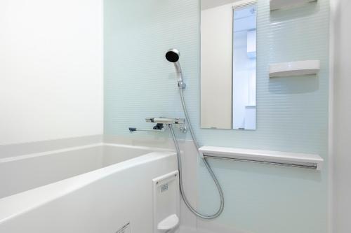 a white bathroom with a shower with a mirror at Brilliant MK- III in Tokyo