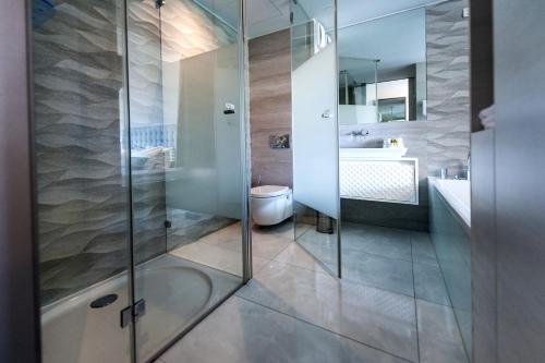 a bathroom with a shower and a toilet and a sink at Hotel Arupinum in Rovinj