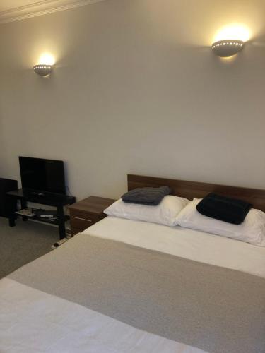 a bedroom with two beds and a flat screen tv at Oxford Street Two Bed Apartment in London