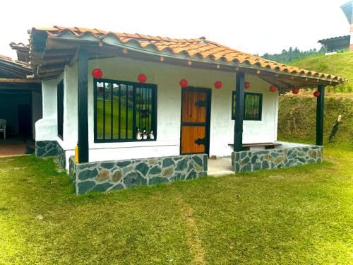 ein kleines Haus mit einer Tür im Gras in der Unterkunft La Colina Magik in Guarne