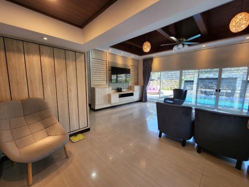 a living room with a bar and chairs and a television at I am pool villa Pattaya no14 in Ban Nong Phlap