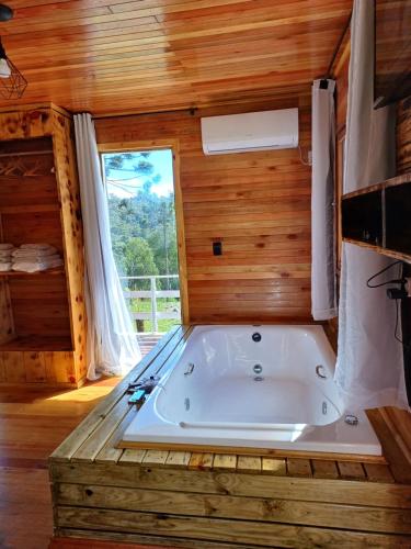 a large bath tub in a room with a window at Recanto do Ipê cabana 01 in Urubici