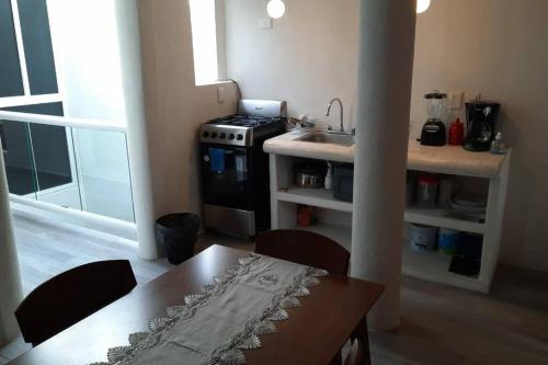 Una cocina con una mesa, un fregadero y una estufa. en Loft guelaguetza A, en Santa Cruz Huatulco