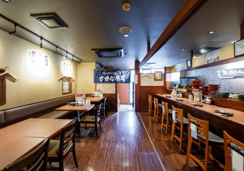 a dining room with wooden tables and chairs at TKP Sunlife Hotel in Fukuoka