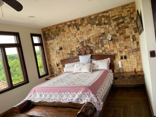 基姆巴亞的住宿－Cattleya tropical，一间卧室设有一张床和砖墙