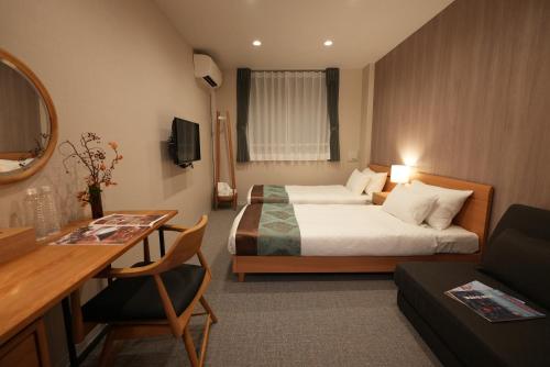 a hotel room with two beds and a desk at 谷町君 HOTEL 京都駅東29 in Gionmachi
