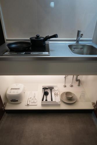 a kitchen counter with a stove and a sink at 谷町君 HOTEL 京都駅東29 in Gionmachi