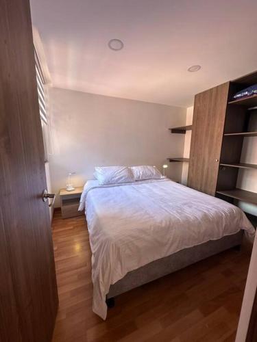 Schlafzimmer mit einem Bett und Holzboden in der Unterkunft Hermoso apartamento en Cajicá in Cajicá
