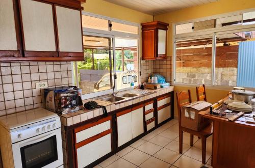 Il comprend une cuisine équipée d'un évier et d'une cuisinière. dans l'établissement Fare Moana Bord de Mer Fare Tepua Lodge, à Uturoa