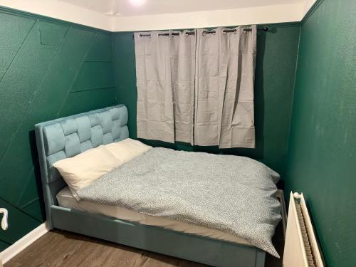 Habitación verde pequeña con cama con cortina en Warm Home in Birmingham's Peaceful Green Oasis, en Frankley
