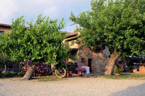 two trees in front of a stone house at Casa Di Campagna In Toscana in Sovicille