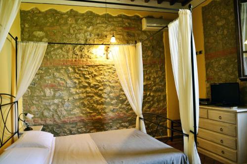 a bedroom with two beds and a stone wall at Casa Di Campagna In Toscana in Sovicille