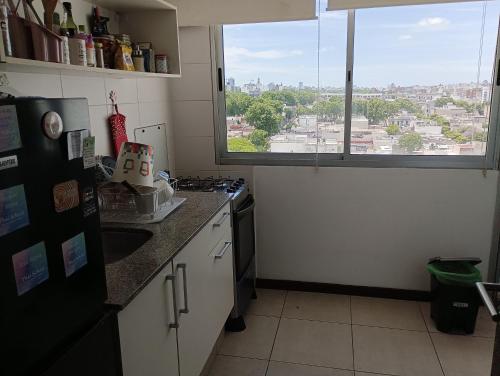 una cocina con vistas a la ciudad desde una ventana en Buena vista y locacion en Montevideo