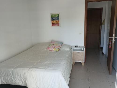 um pequeno quarto com uma cama e uma mesa de cabeceira em Buena vista y locacion em Montevidéu