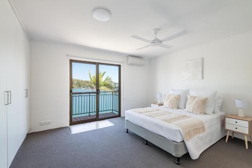 ヌーサヘッズにあるRiverside Gem, Noosa Headsのベッドと窓のある白い寝室