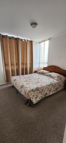 a bedroom with a bed with a floral bedspread at Chinchorro in Arica