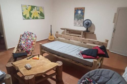 a room with a bed and a table and a guitar at Casa cânions Furnas in São José da Barra