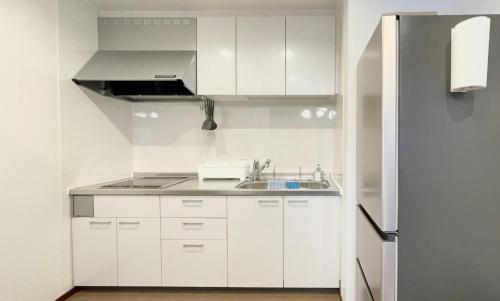 una cucina bianca con lavandino e frigorifero di Miyabi-Minami Atami - Vacation STAY 98795v ad Atami
