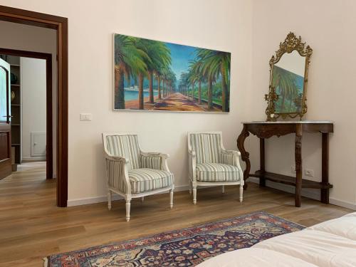a bedroom with two chairs and a table and a mirror at CASA BASTIO in La Spezia