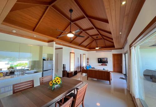 a kitchen and dining room with a wooden ceiling at Villa Tantawan Resort - Private Pool Villas in Kamala Beach