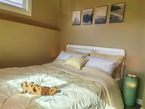 un lit blanc avec un animal rembourré au dessus dans l'établissement Sunny and cozy art-house. No share., à Vancouver