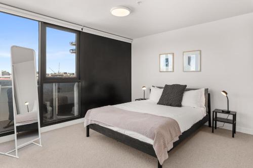 a bedroom with a large bed and large windows at Boutique Stays - Camillea in Melbourne