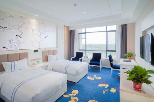 Huayin的住宿－华山欣源国际酒店，一间酒店客房,设有两张床和电视