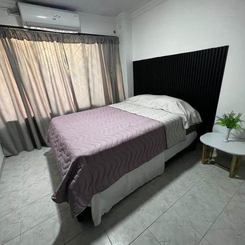 1 dormitorio con 1 cama grande y 1 mesa en Apartamentos San José, en Cartagena de Indias