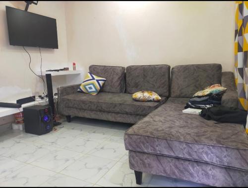 sala de estar con sofá y TV en Golden Home en Maseno