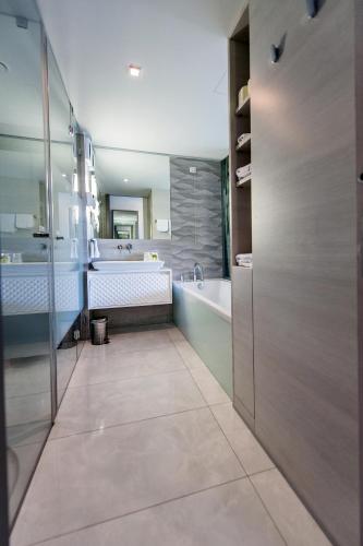 a large bathroom with a tub and a sink at Hotel Arupinum in Rovinj