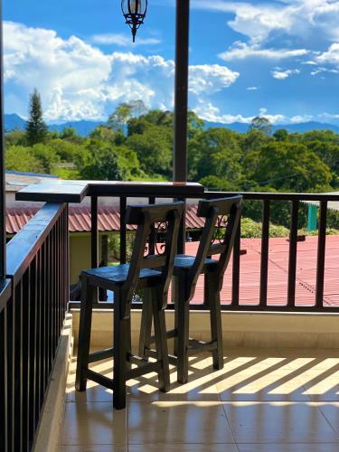 a table and a chair sitting on a balcony at Hotel Casa campestre HH in Quimbaya