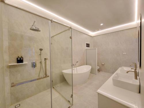 a bathroom with a shower and a toilet and a sink at Niyham Pool Villa in Bang Phli