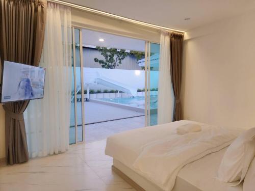 a bedroom with a bed and a view of a pool at Niyham Pool Villa in Bang Phli