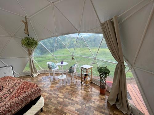 Zimmer mit einem Bett und einem Tisch in einem Zelt in der Unterkunft La Comarca River Glamping Dome near Manuel Antonio in Manuel Antonio