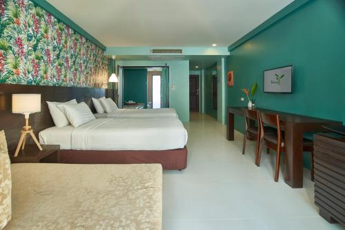 a hotel room with two beds and a desk at The Bihai Hua Hin in Hua Hin