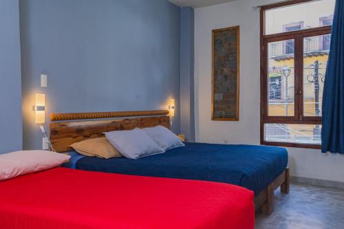 a bedroom with two beds and a window at Hotel Corazón de Plata Centro in Guanajuato