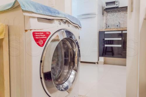 uma máquina de lavar roupa com uma toalha em cima na cozinha em Studio Living Lê Premier Jardins em São Paulo