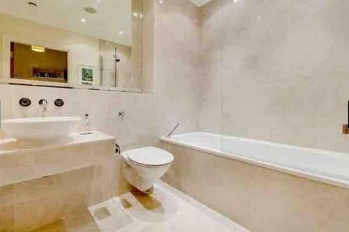 a bathroom with a sink and a toilet and a bath tub at Beautiful apartment in Kew, Richmond London with Free Underground Parking in London