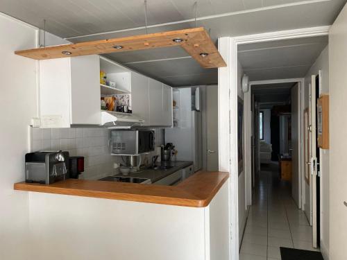 une cuisine avec des armoires blanches et un comptoir dans l'établissement Appartement confort proche pistes, WIFI gratuit, 8 pers, Flaine - FR-1-425-211, à Arâches-la-Frasse