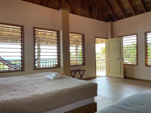 ein Schlafzimmer mit einem Bett in einem Zimmer mit Fenstern in der Unterkunft Hotel Guanaja in Guanaja