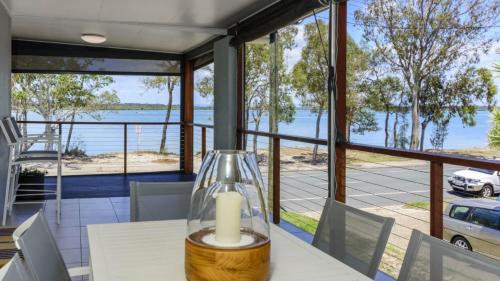 a candle on a table with a view of the water at Fishing and Swimming at your doorstep - Sylvan Beach Esp, Bellara in Bellara